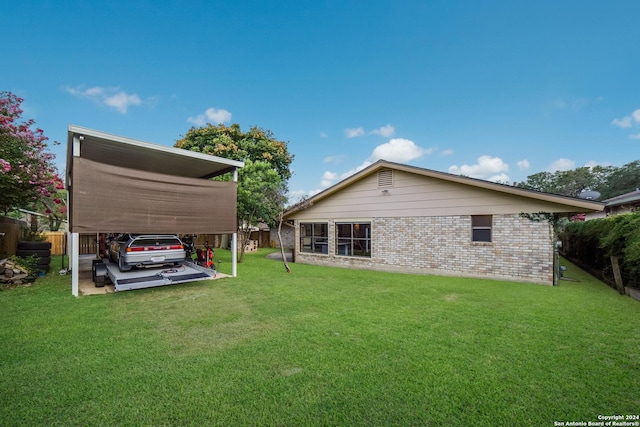 rear view of house with a carport and a yard