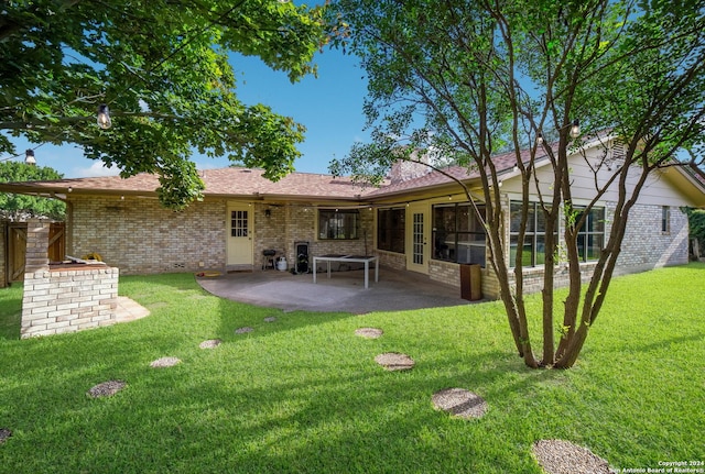 rear view of house featuring a patio and a yard