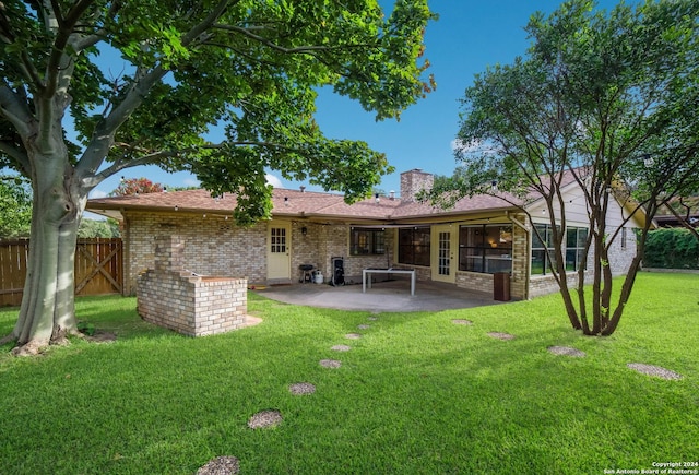 rear view of property featuring a yard and a patio area