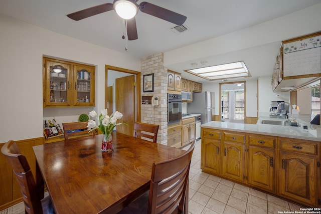 dining room with light tile patterned flooring, sink, and ceiling fan