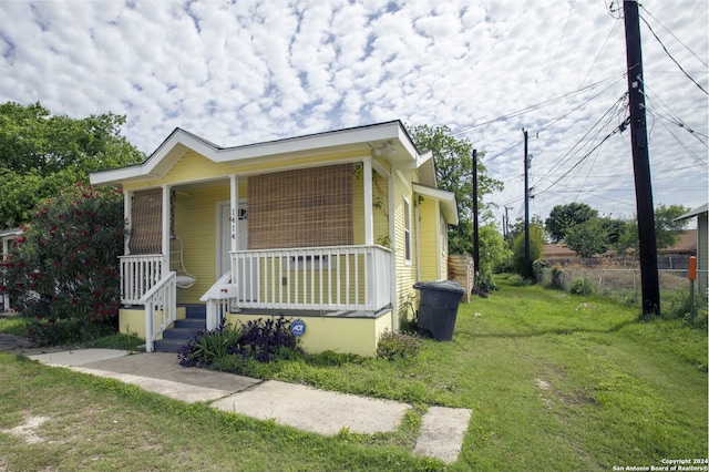 bungalow-style house with covered porch and a front lawn