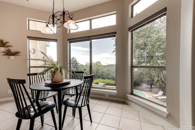 dining space with a healthy amount of sunlight, light tile patterned floors, and a chandelier