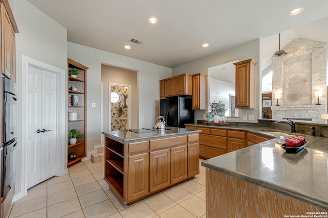 kitchen featuring black appliances, light tile patterned floors, kitchen peninsula, and sink