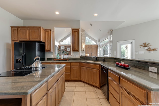 kitchen featuring a kitchen island, black appliances, sink, lofted ceiling, and light tile patterned flooring