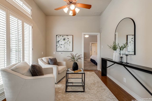 living room with dark wood-type flooring and ceiling fan