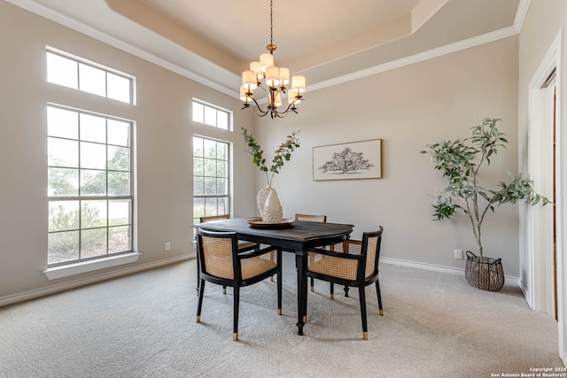 carpeted dining area featuring a wealth of natural light, an inviting chandelier, a raised ceiling, and crown molding