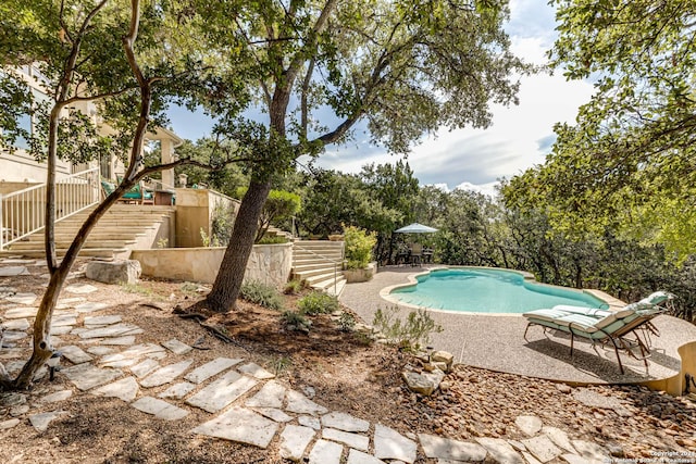 pool with stairway and a patio area