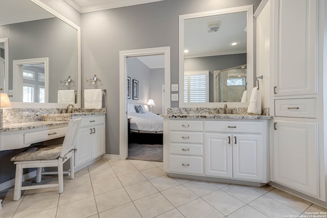 bathroom with a shower with door, vanity, and tile patterned flooring