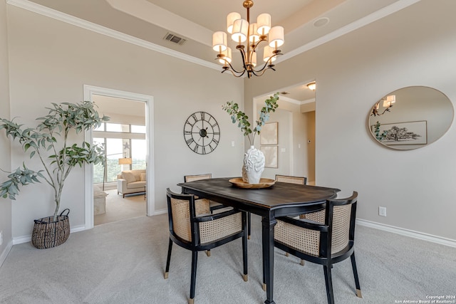 carpeted dining space featuring a tray ceiling, ornamental molding, and a chandelier