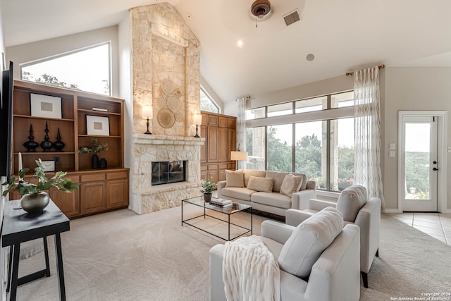 carpeted living room with a stone fireplace and high vaulted ceiling