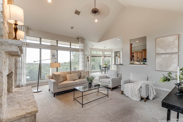 living room featuring light carpet, a premium fireplace, high vaulted ceiling, and ceiling fan