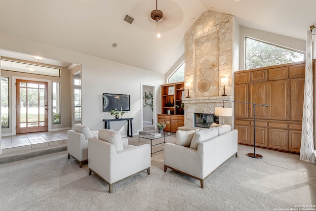 carpeted living room with a fireplace, high vaulted ceiling, and ceiling fan