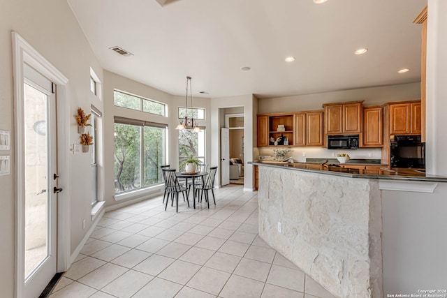 kitchen with black appliances, hanging light fixtures, light tile patterned floors, and kitchen peninsula