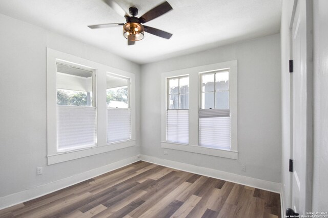 empty room featuring plenty of natural light, ceiling fan, and hardwood / wood-style floors