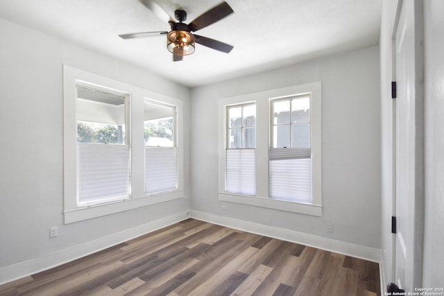 spare room with dark wood-type flooring and ceiling fan