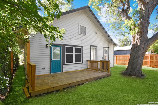 back of house featuring a yard and a wooden deck