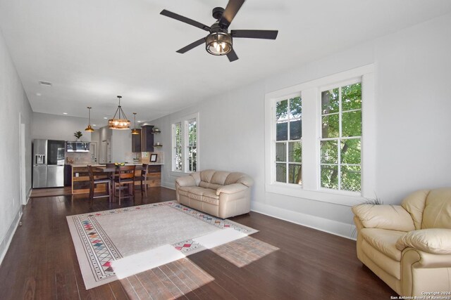 living room with dark hardwood / wood-style flooring and ceiling fan