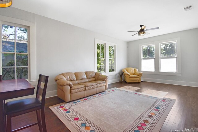 living room featuring ceiling fan and dark hardwood / wood-style flooring