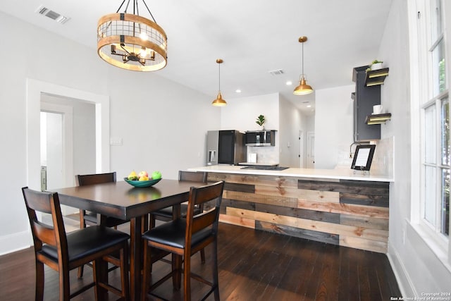 dining space with a notable chandelier and dark hardwood / wood-style flooring