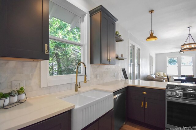 kitchen featuring stainless steel appliances, sink, pendant lighting, decorative backsplash, and wood-type flooring