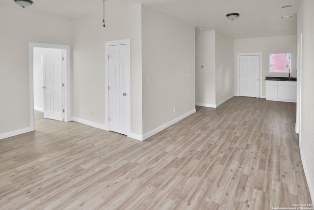 unfurnished room featuring sink and light hardwood / wood-style flooring