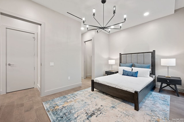 bedroom featuring an inviting chandelier and hardwood / wood-style floors