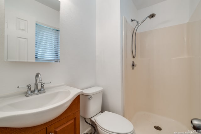 bathroom with vanity, walk in shower, and toilet