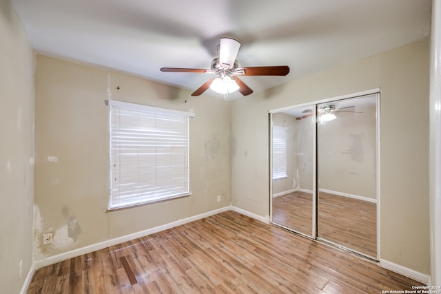 unfurnished bedroom featuring light hardwood / wood-style flooring, a closet, and ceiling fan