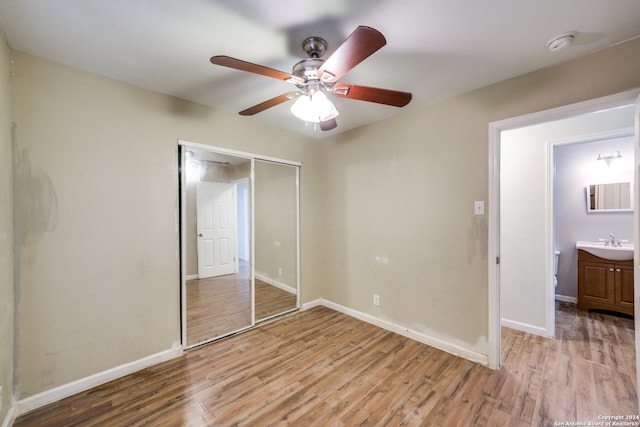 unfurnished bedroom with ensuite bath, ceiling fan, light hardwood / wood-style floors, a closet, and sink