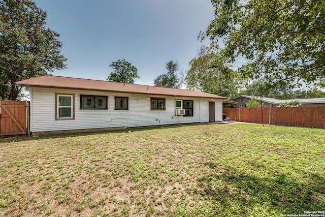 rear view of property with cooling unit and a yard