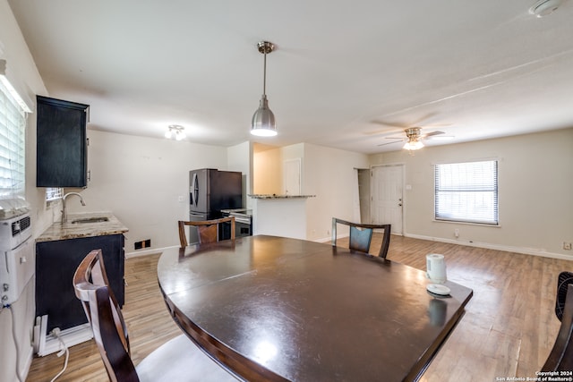 dining area featuring sink, light hardwood / wood-style flooring, and ceiling fan