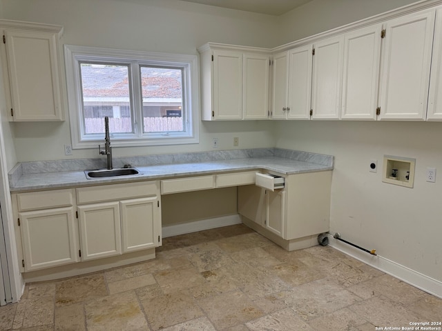 kitchen featuring built in desk, sink, and white cabinets