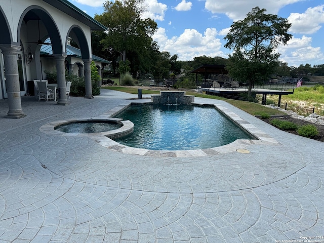 view of swimming pool with a patio and an in ground hot tub