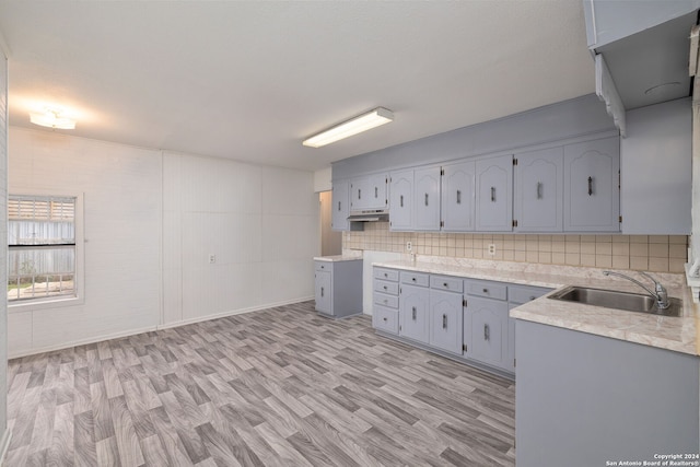 kitchen featuring tasteful backsplash, sink, gray cabinetry, and light hardwood / wood-style floors