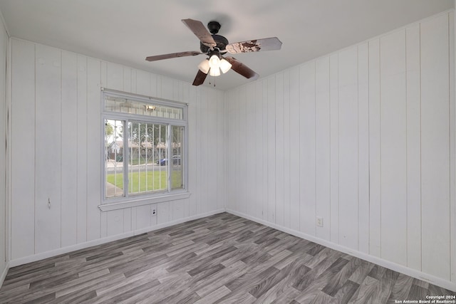 empty room with ceiling fan and light hardwood / wood-style floors