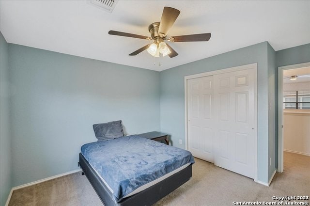 carpeted bedroom with a closet and ceiling fan