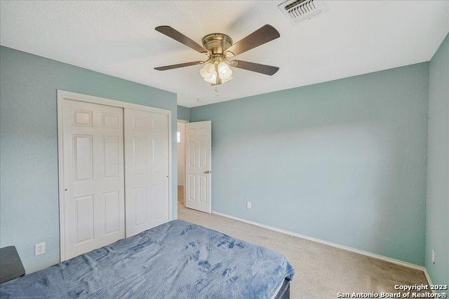 unfurnished bedroom with light colored carpet, a closet, and ceiling fan