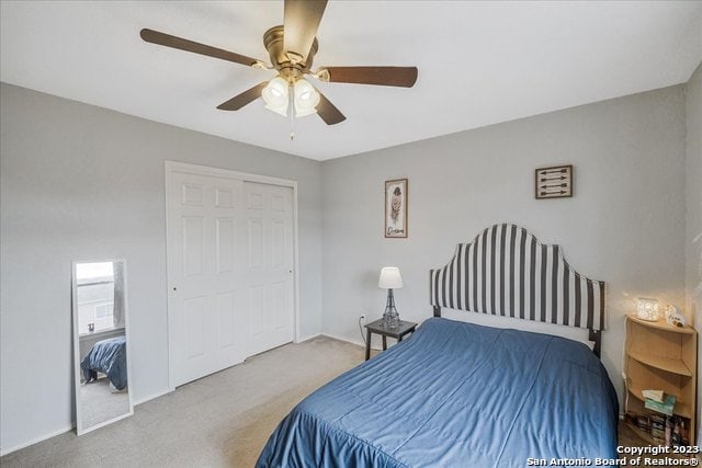 carpeted bedroom with a closet and ceiling fan