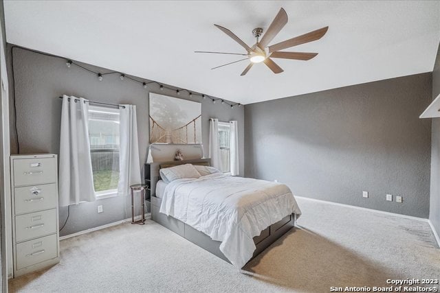 bedroom featuring light colored carpet and ceiling fan