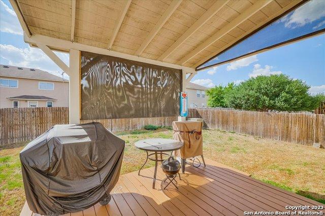 wooden deck featuring area for grilling and a lawn