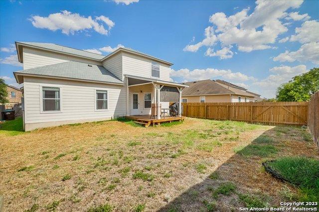 back of property featuring a wooden deck and a lawn