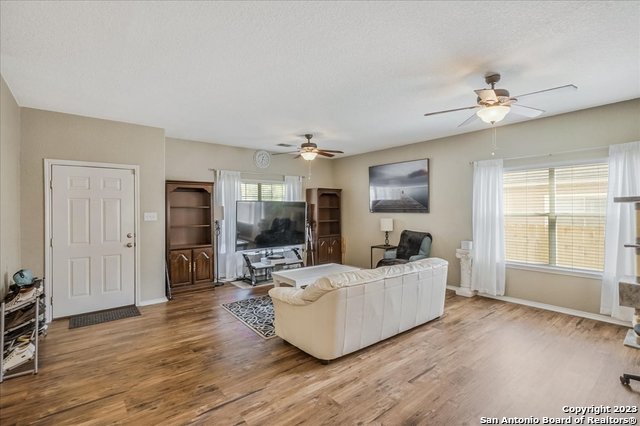 living room featuring hardwood / wood-style flooring, ceiling fan, and plenty of natural light