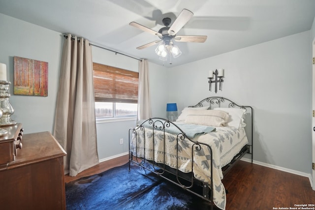 bedroom featuring baseboards, dark wood finished floors, and a ceiling fan