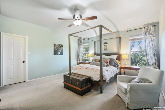 bedroom with baseboards, multiple windows, a ceiling fan, and light colored carpet