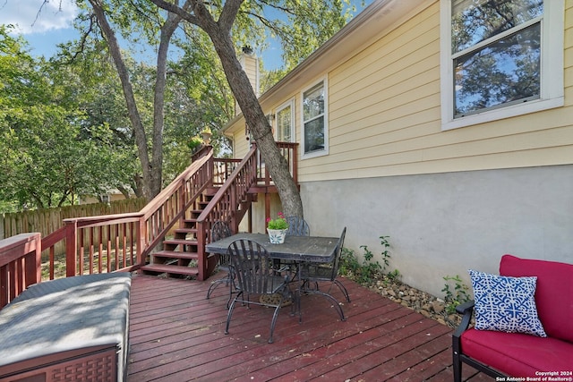 wooden terrace with fence, stairway, and outdoor dining space