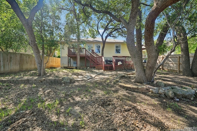 rear view of property featuring stairway, a fenced backyard, and a deck