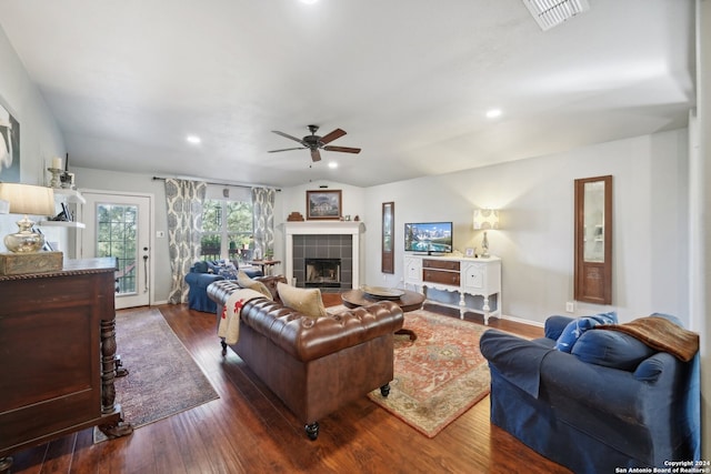 living area with ceiling fan, dark wood-type flooring, a fireplace, visible vents, and baseboards