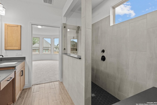 bathroom with vanity and a tile shower