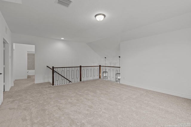 spare room with light carpet and lofted ceiling