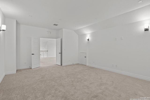 carpeted empty room with vaulted ceiling